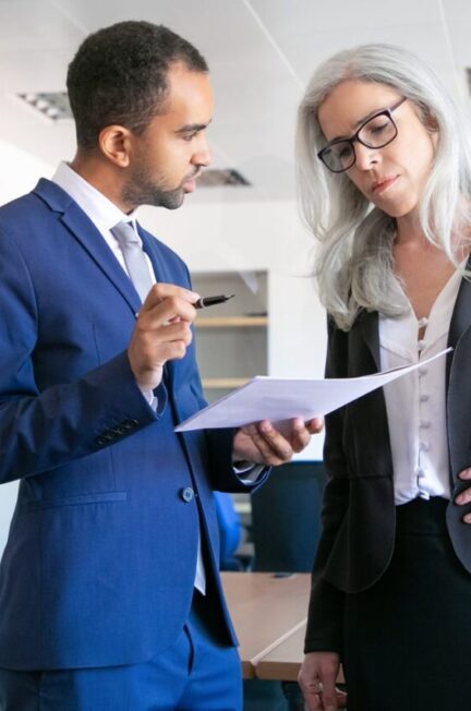 Deux associés examinent un contrat autour d’une table de réunion.