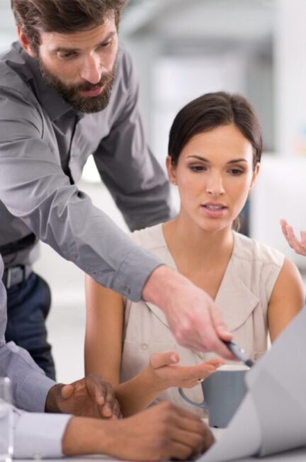 Réunion d’équipe où des collaborateurs discutent pour résoudre un désaccord sur la communication client.